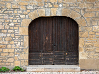 Double wooden door old building entrance closed with arch on street ancient