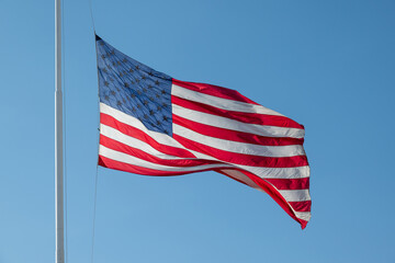 USA flag against blue sky.