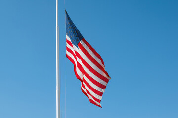 USA flag against blue sky.