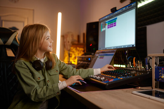 Young sound producer girl working on audio mixing board