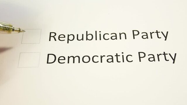 The pen selects the desired column in the paper ballot. The choice between the Republican Party and the Democratic Party. Paper ballot for the November 2022 US Senate midterm elections