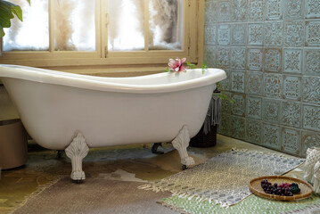 vintage white bathtub on foots by the window retro style home interior