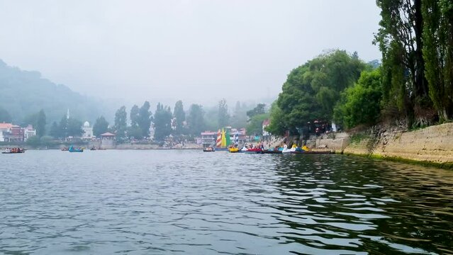 low near water shot of boat stand on the fog covered banks of naini jheel in nainital uttarkashi a popular tourist spot in the hot summers of India