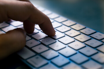 wireless computer keyboard with human hand close-up. toned