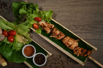 Bamboo barrel plat with grilled meat skewers on wooden table. Mala Chinese BBQ is meat or vegetable grilled with Chinese hot and spicy spices