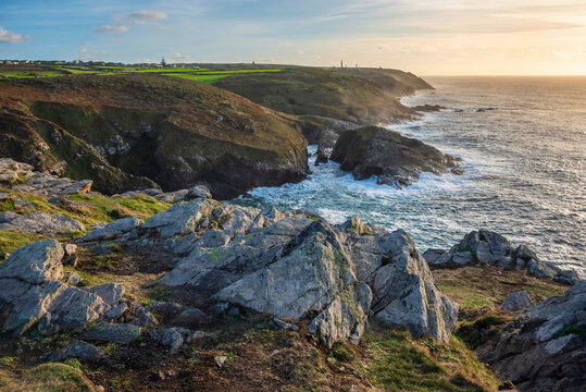 Stunning sunset landscape image of Cornwall cliff coastline with tin mines in background viewed from Pendeen Lighthouse headland
