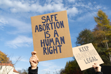 Protesters holding signs with slogans Safe abortion is a human right and Keep abortion legal....