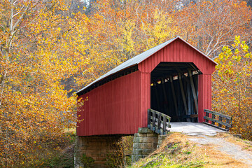 Red covered bridge in bright fall foliage