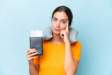 Naklejka premium Young beautiful woman with Inflatable travel Pillow isolated on blue background thinking an idea
