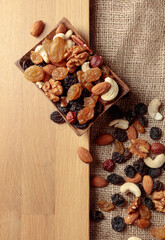 Mix of nuts and raisins on a wooden table.