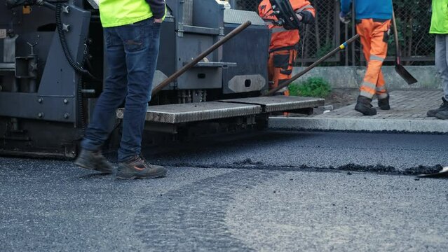 Road Paving Machine Roadworks Asphalt Laying Machine Operated by Workers Wearing Protective Workwear