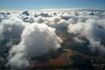 Aerial view at high altitude of earth covered with puffy cumulus clouds forming before rainstorm