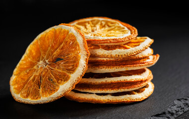 a stack of round slices of dried orange on a black background