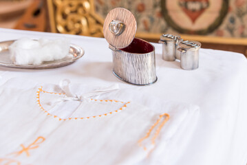 chrisam oil in a vessel and holy water in a bowl - preparation for the sacrament baptism