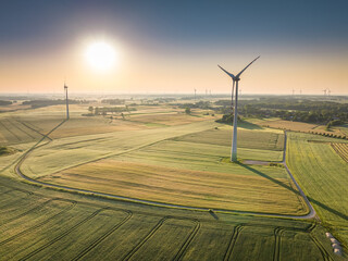 Wind turbines on green field in spring, aerial view