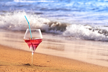 Wine glass with a cocktail by the sea.