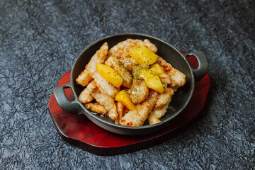 Chinese food sweet and sour pork dish in black bowl