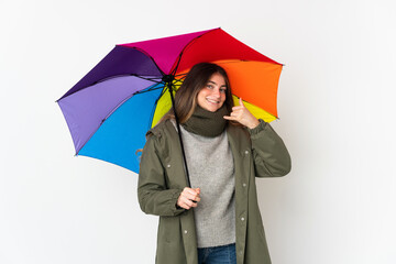 Young caucasian woman holding an umbrella isolated on white background making phone gesture. Call me back sign