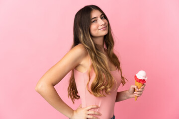 Obraz na płótnie Canvas Young caucasian woman with a cornet ice cream isolated on pink background suffering from backache for having made an effort