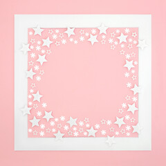 Christmas festive minimal background composition with stars and snowflakes on pink with white frame. Winter Xmas and New Year creative design for the holiday season.