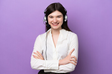 Telemarketer Russian woman working with a headset isolated on purple background keeping the arms...