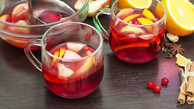 Making hot alcohol, cook mulled wine at home. add orange, apples and spices. traditional drink in winter, for christmas and new year holidays. stock pot, mixed with soup ladle. Closeup
