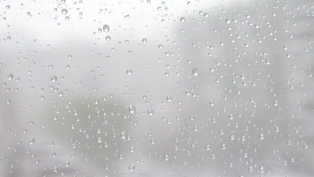 Window glass background during sleet.close-up of a drop of snow melting on the window glass. Snowfall outside the window.bad weather thaw melting snow on the window .selective focus