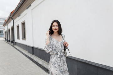 Stylish pretty elegant spring girl with hairstyle in fashion flowers long dress with fashionable...