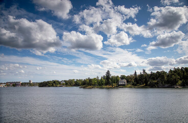 Fototapeta premium The shore of the sea bay and houses under the summer cloudy sky