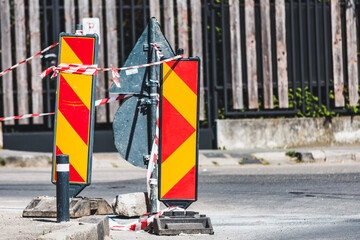 Stiped horizontal road sign with red and yellow colors that warns an area under construction