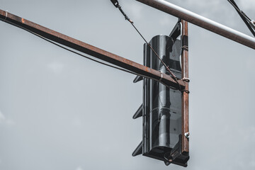 Back side of a traffic semaphore hanging by metal bars