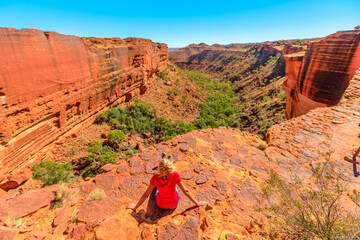 woman on the edge of Kings Canyon in Watarrka National Park, Australia's Red Center. rest after...