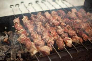 Meat is fried outside. Raw meat planted on blades. Heating food on coals.