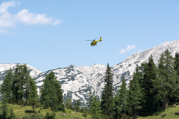 yellow helicopter landing in the mountains