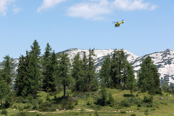 yellow helicopter landing in the mountains