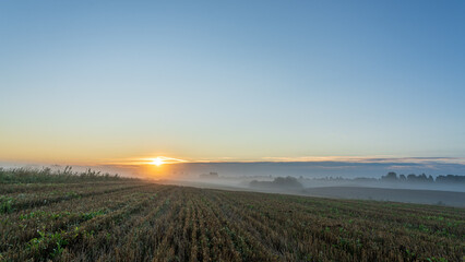 foggy on the mown field, sunrise in countryside.