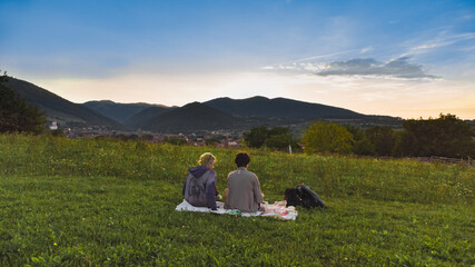 two persons on picnic on background mountains and forests photographed from a drone Transylvania, Romania