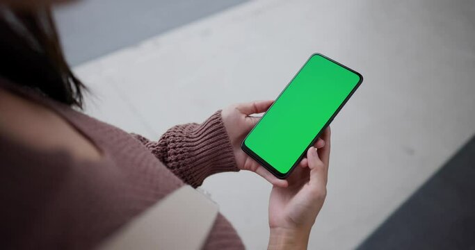 Woman hold with cellphone with green screen at outdoor