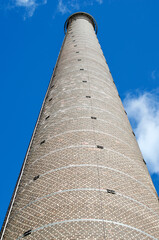 a tall old industrial chimney made of bricks - 543642772