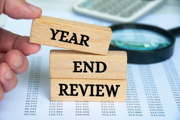 Year end review text on wooden blocks. Year end review and business concept.