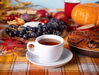 Obraz na płótnie Canvas Cup of tea. Hot autumn drink beverage. Nearby delicious pie and appetizers fruits and cheese. Cozy and warm season.