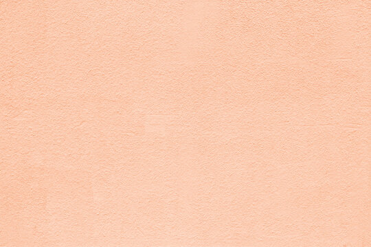 Pastel peach orange color old textured plaster background. Light rough wall texture