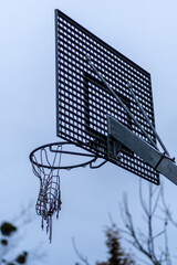 stara metalowa tablica z koszem do gry w koszykówkę na tle nieba