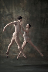 Young man and woman, ballet dancers performing isolated over dark green vintage background. Tenderness and passion