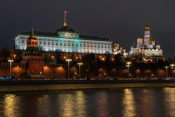 View of the building of the Grand Kremlin Palace, the Annunciation Tower and the ensemble of the Kremlin Cathedral Square from the embankment of the Moskva River with night lighting, Moscow, Russia