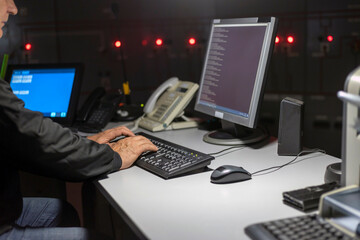 A self-confident specialist works on a personal computer, he controls the energy facility.