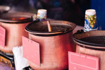 Traditional mulled wine, a winter street drink, prepared and heated in a pot in winter at a street...