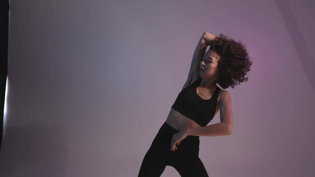 Curly-haired girl dances contemporary. Dynamic dance video