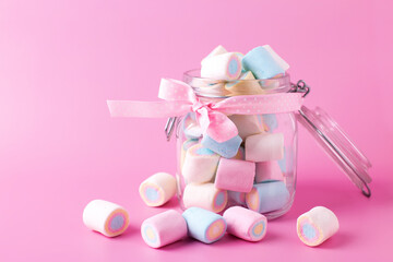 Sweet marshmallows  in  bank on jar on pink pastel background. Place for text. Postcard for birthday, Valentine day.