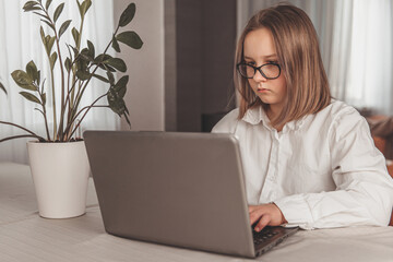 Schoolgirl studying with video online lesson at home. Remote education, work from home concept